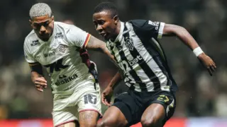 Marinho, do Vitória, em disputa de bola com Minda, do Atlético-MG.