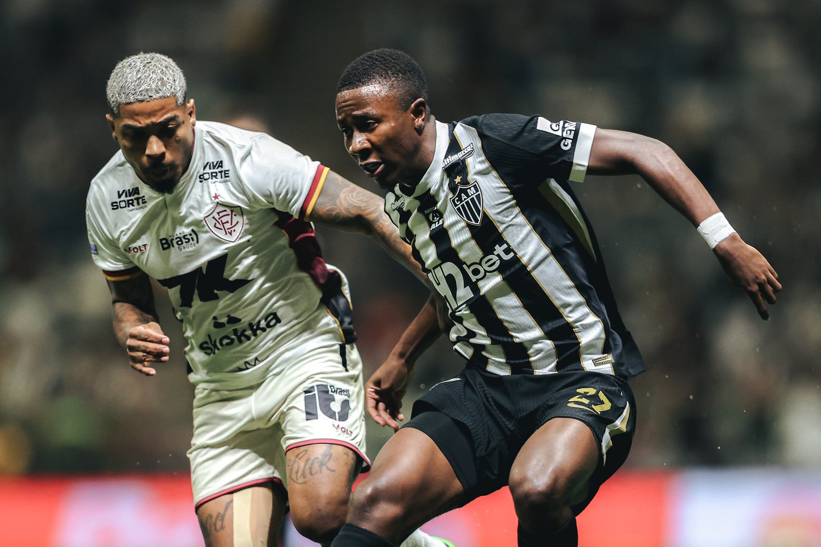 Marinho, do Vitória, em disputa de bola com Minda, do Atlético-MG.