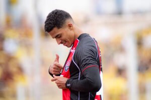 Renê souza apontando para o escudo do Vitória na camisa