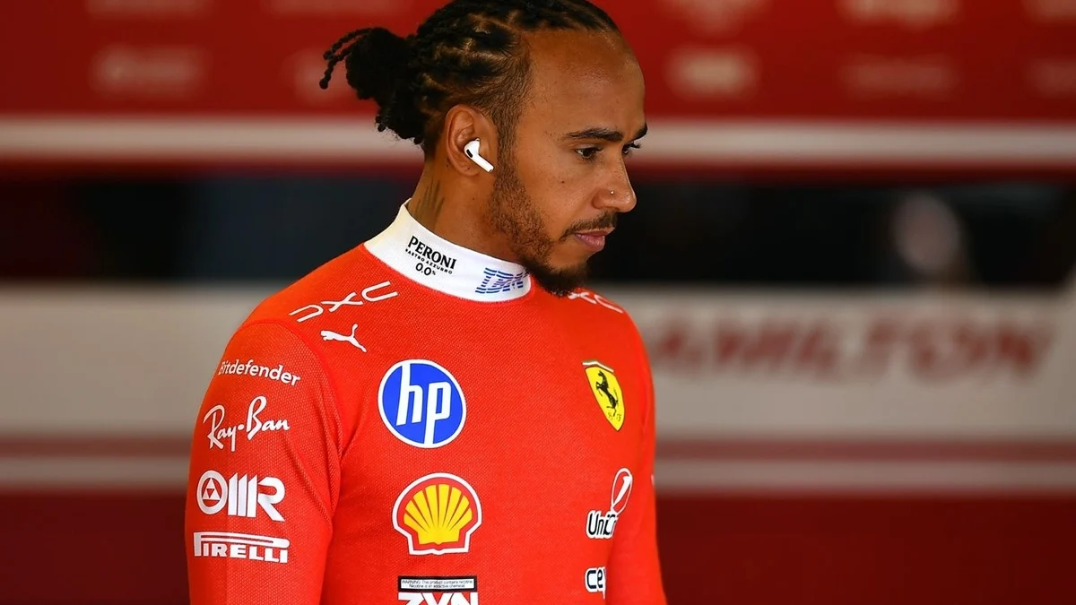 Lewis Hamilton em entrevista com microfones à sua frente, sorrindo e gesticulando