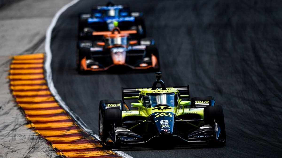 Carros da IndyCar disputando corrida em circuito misto