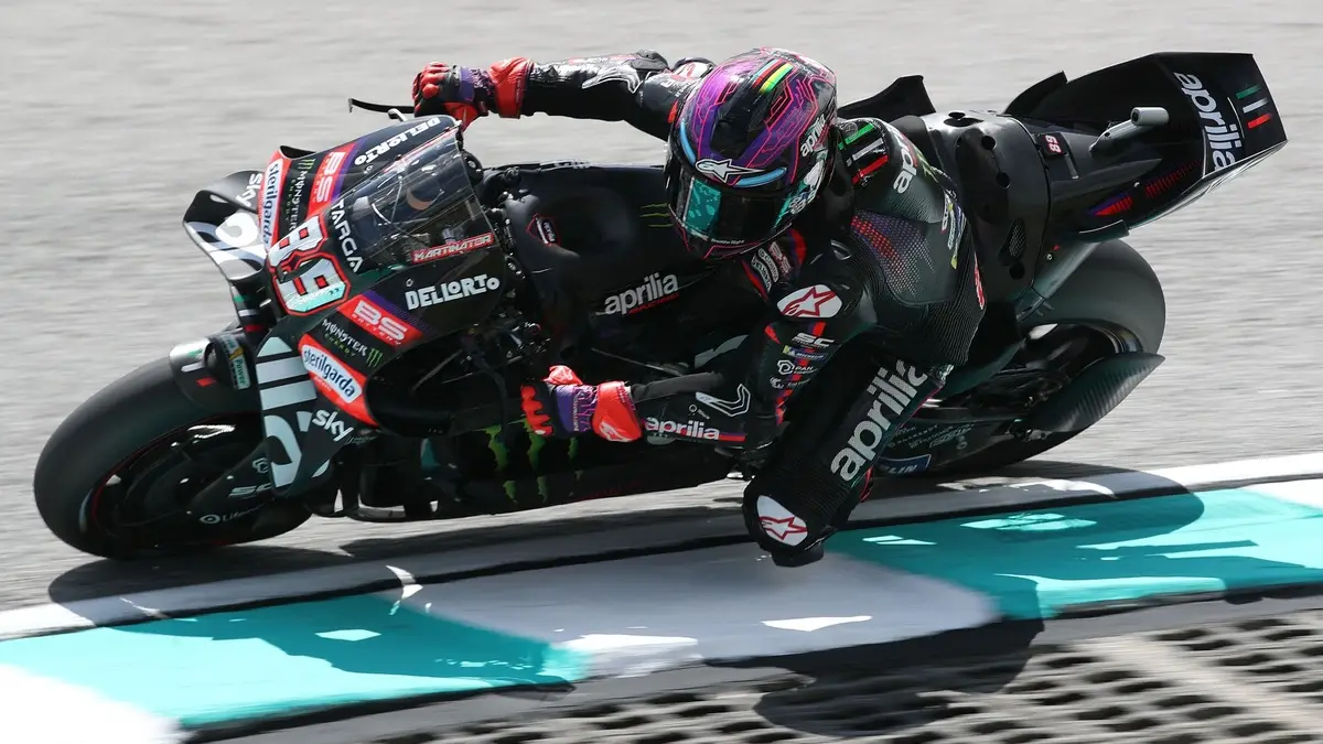 Jorge Martín pilotando uma moto Aprilia em uma pista de corrida, com capacete e macacão de piloto