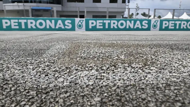 Moto de MotoGP em ação no circuito de Sepang, Malásia, com o asfalto apresentando sinais de desgaste