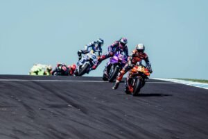 Vista aérea do circuito de Phillip Island durante uma corrida de MotoGP, com o oceano ao fundo e público nas arquibancadas