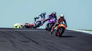 Vista aérea do circuito de Phillip Island durante uma corrida de MotoGP, com o oceano ao fundo e público nas arquibancadas