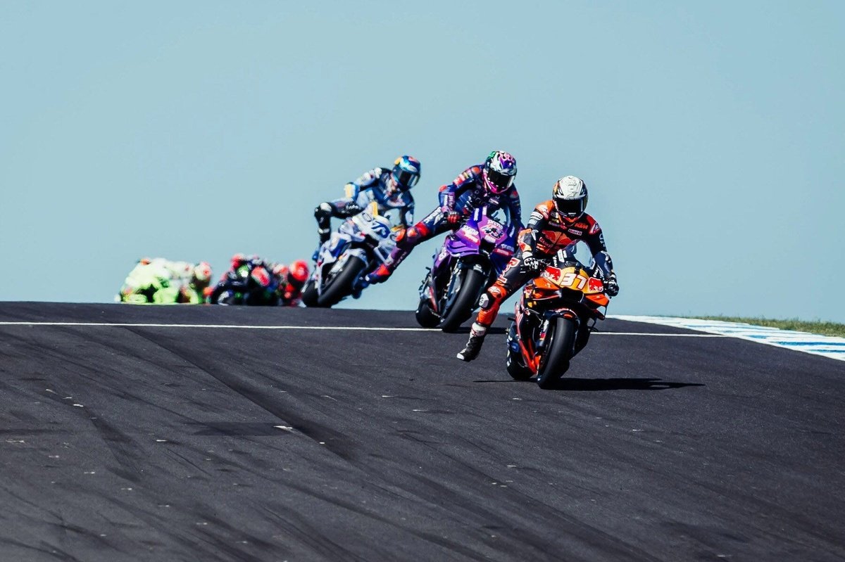 Vista aérea do circuito de Phillip Island durante uma corrida de MotoGP, com o oceano ao fundo e público nas arquibancadas