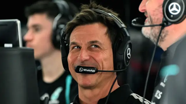 Toto Wolff em uma corrida de Fórmula 1, com o carro da Mercedes ao fundo
